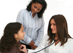 Nurse listening to a young girls heartbeat.