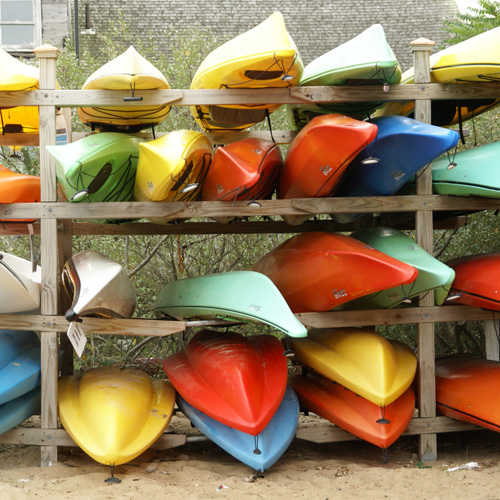 a bunch of kayaks stored on a rack
