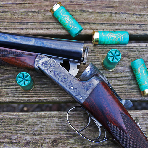 a shotgun and some shells resting on a table