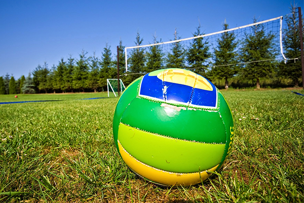 a volleyball on the ground in front of a volleyball net and court