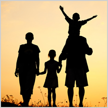 a family in front of a sunset