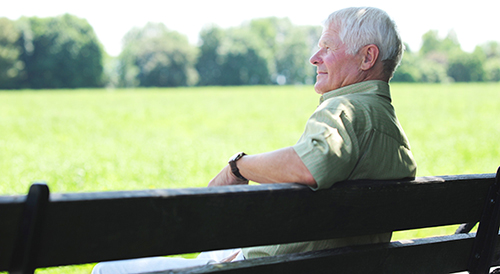 elderly man sitting on park bench