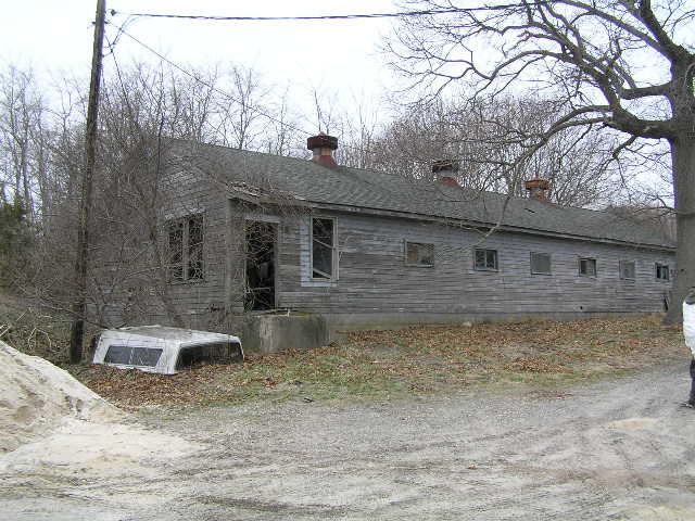 image 46b - an abandoned house, its door is off. a truck bed cap lay on the ground next to the house