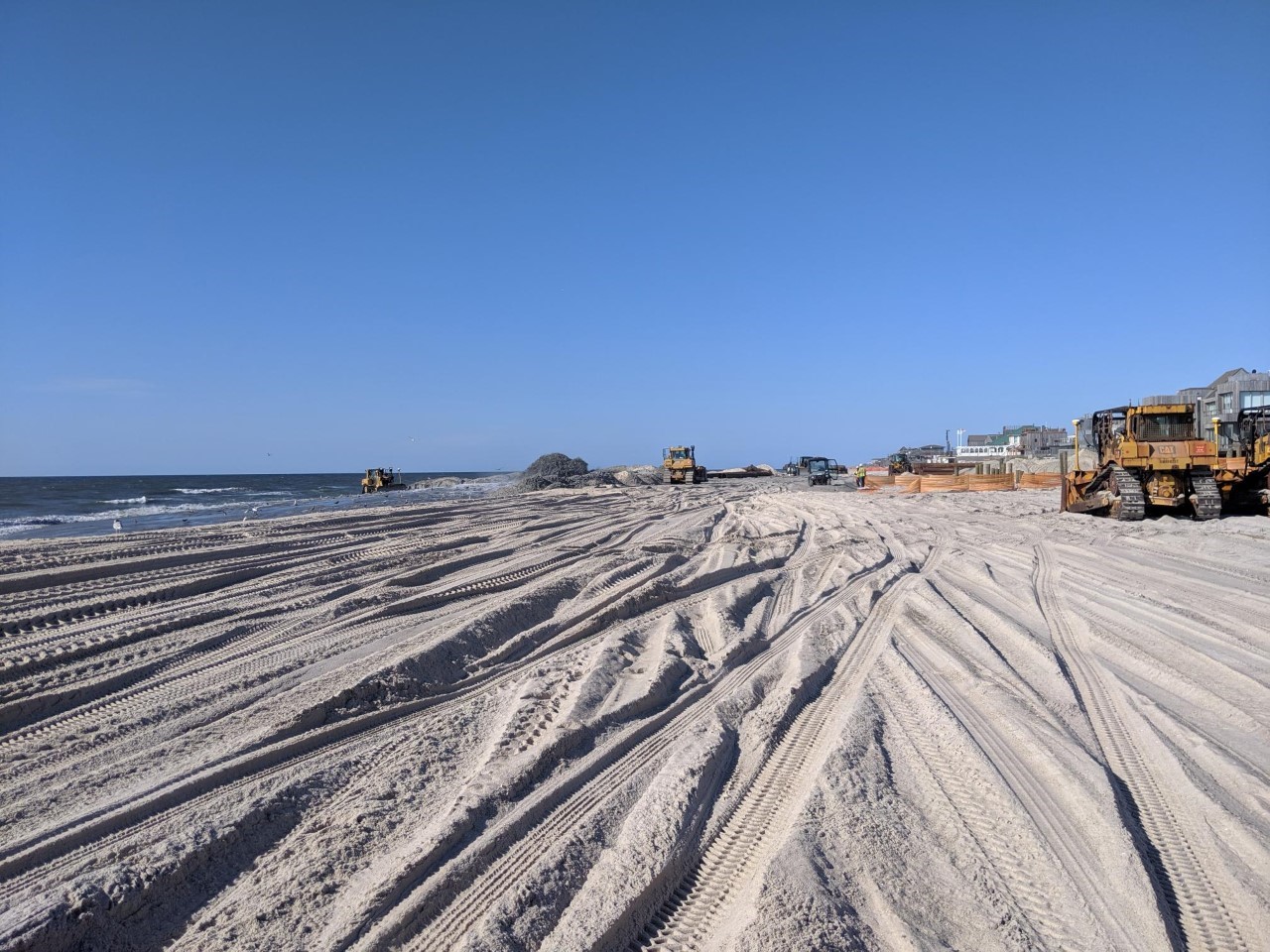 backhoes and trucks working on davis park shoreline