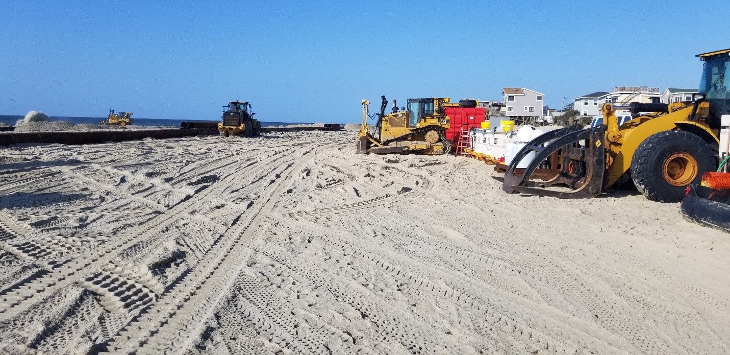 backhoes and trucks working on davis park shoreline