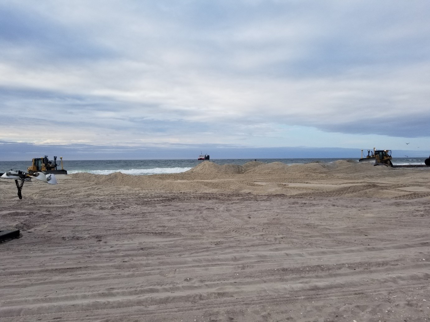 backhoes and trucks working on davis park shoreline nearer to the water