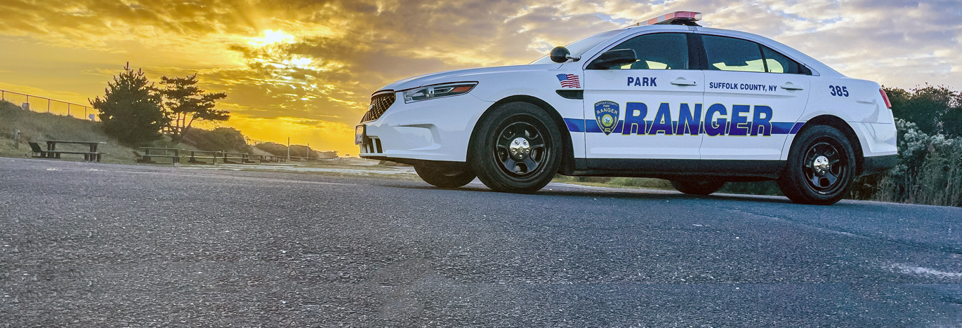 park ranger patrol car in parking lot at sunset